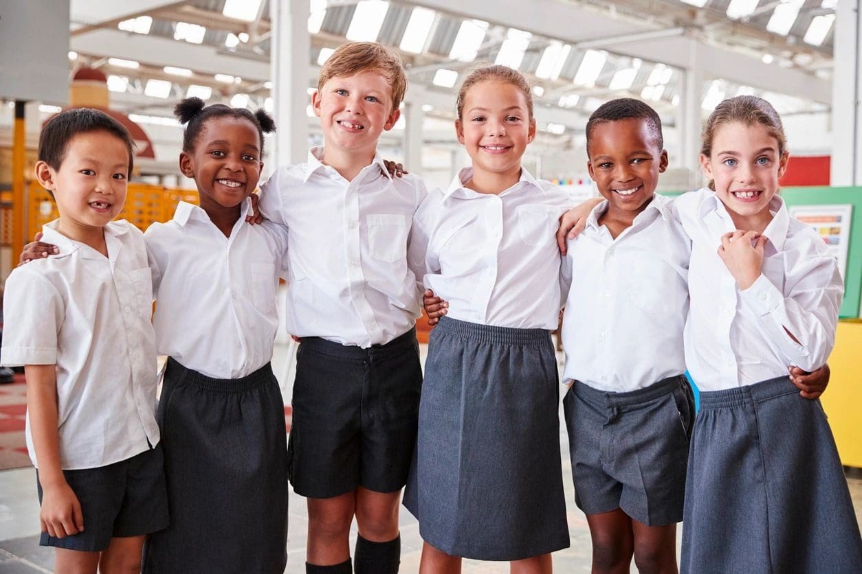 A group of children standing together in school uniforms.