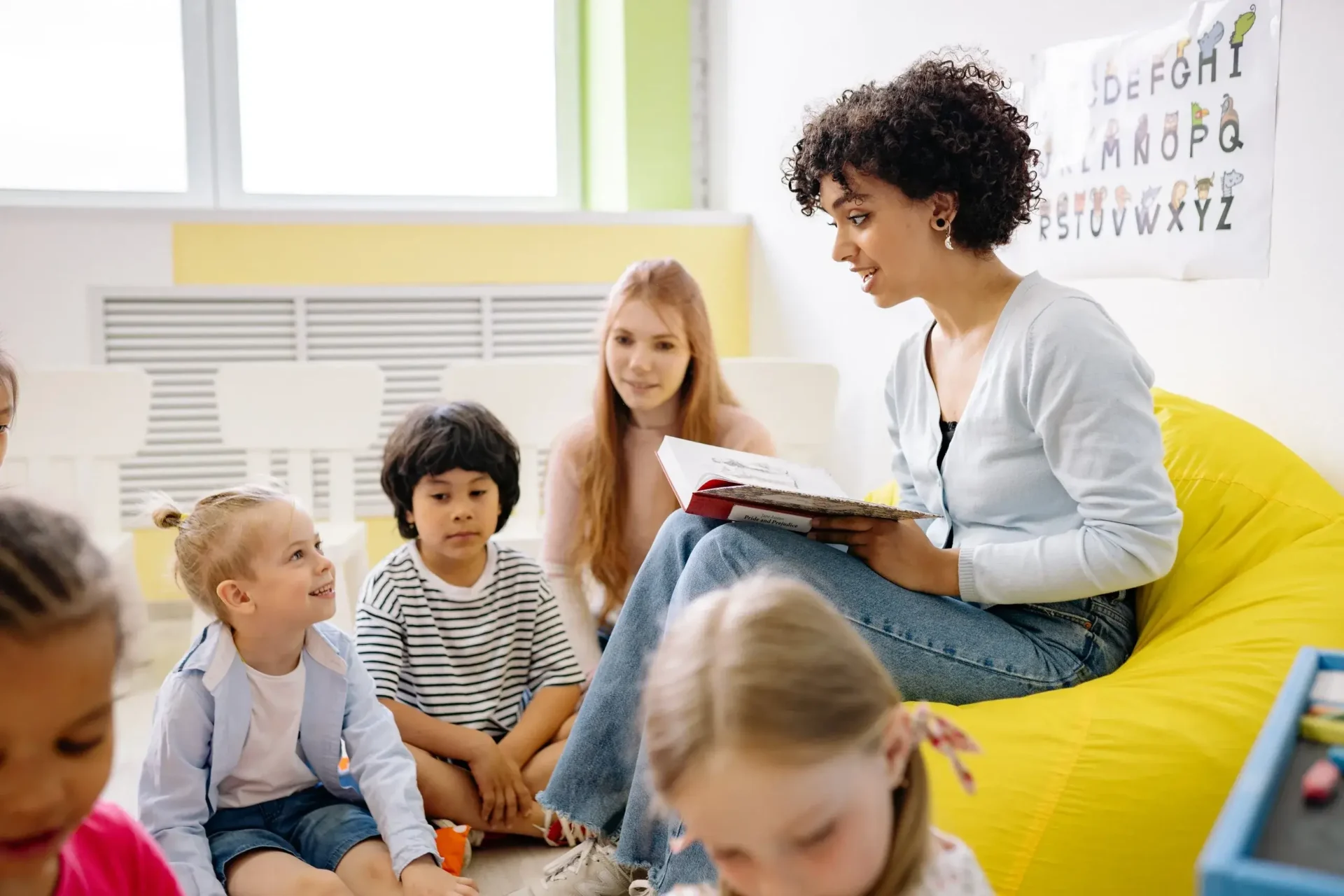 A woman reading to children in a room.