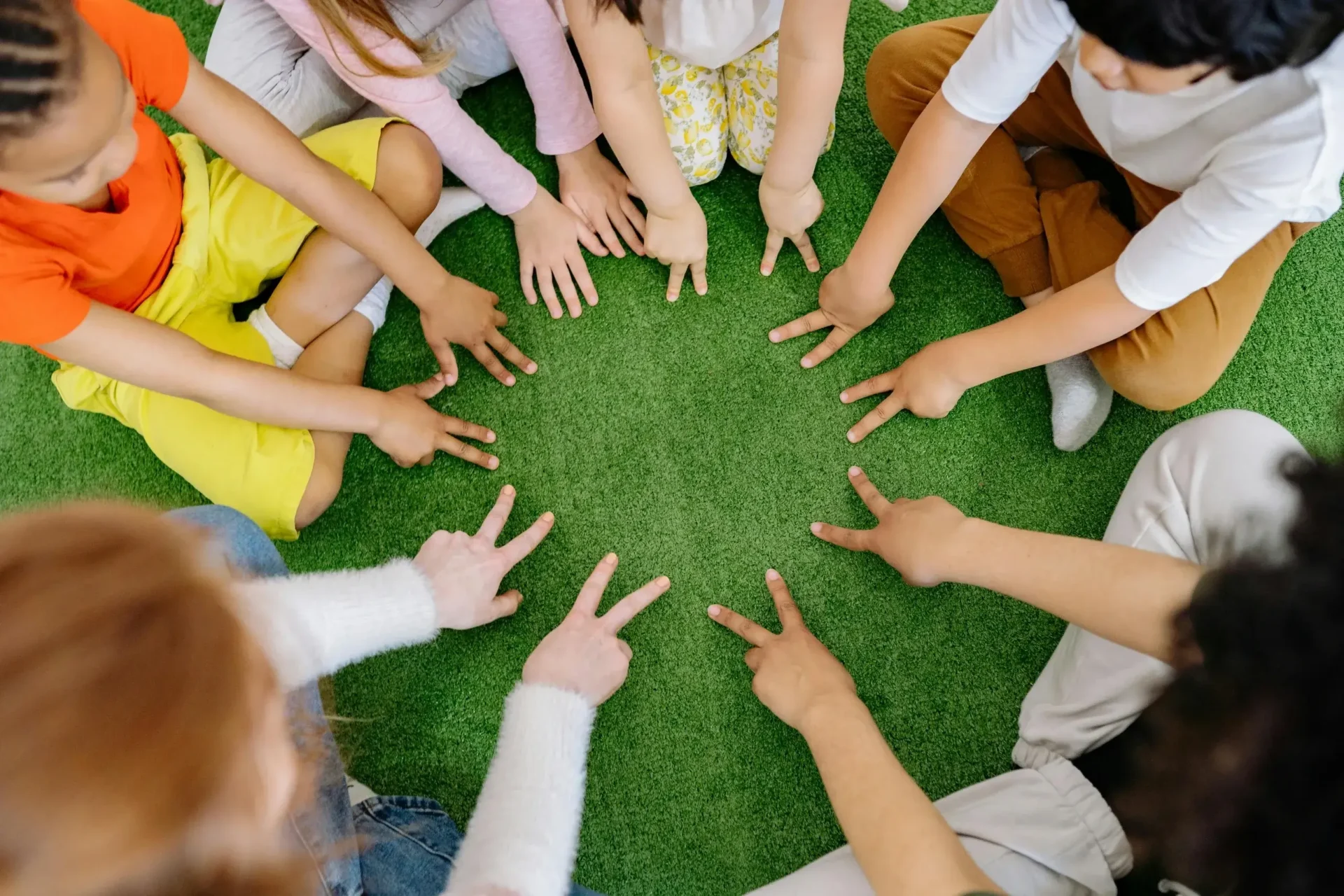 A group of people standing around each other with their hands in the air.